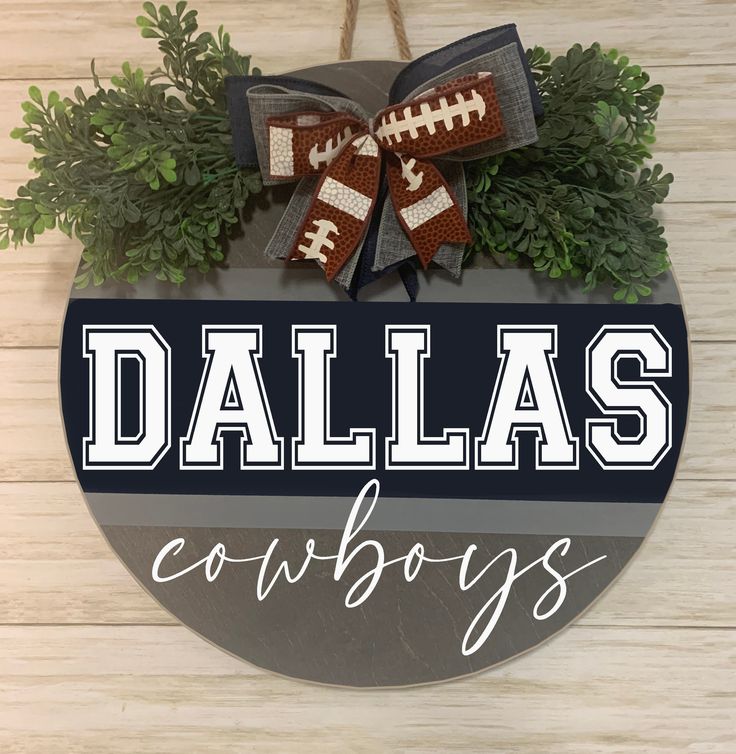 a sign that says, dallas cowboys with footballs hanging from it's side