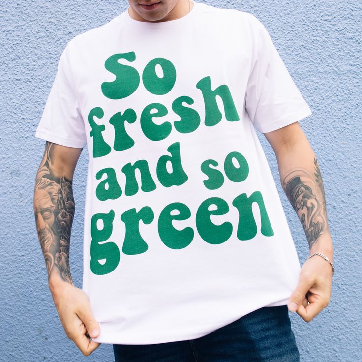 Super fresh.  Printed t-shirt by Batch1 Slogan to front: "So Fresh And So Green" in 70s style typography Print: Organic, water-based, eco-friendly ink Style: Crew neck, short sleeves, soft jersey Fit: Relaxed, Unisex Size Guide (chest to fit):  S - 34/36" | M - 38/40" | L - 42/44" | XL - 46/48" | XXL - 50/52" Model wears size Extra Large  Material: 100% organic cotton Sustainability: Ethically made to order in the UK  | Global Organic Textile Standard | Fair Wear | Vegan  Care: Machine wash Cheap Green Graffiti Print T-shirt, Cheap Green T-shirt With Graffiti Print, Eco-friendly Green Cotton T-shirt, Eco-friendly Green Crew Neck T-shirt, Eco-friendly Graphic Print T-shirt For Summer, Green Eco-friendly Crew Neck T-shirt, Organic White T-shirt For Summer, Green Organic Relaxed Fit T-shirt, Relaxed Fit Green Slogan T-shirt