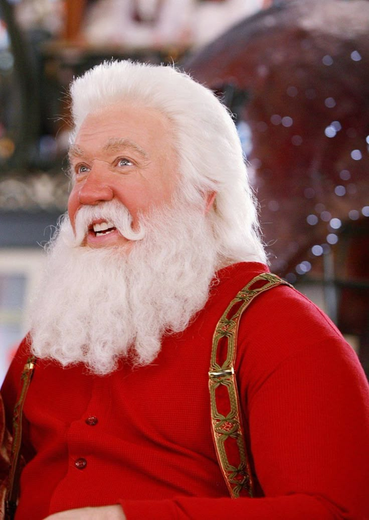 an old man with a white beard wearing a red sweater and suspenders is smiling at the camera