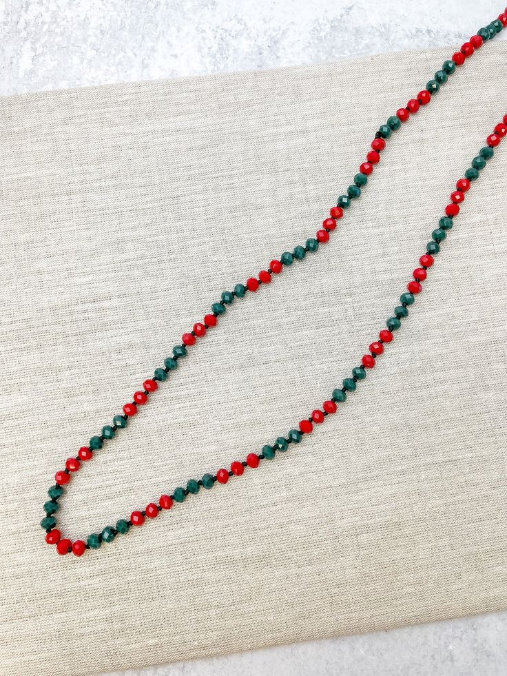 Add a subtle festive statement to your holiday wardrobe! Measures 60" Christmas Party Beaded Necklaces With Round Beads, Christmas Party Round Bead Necklaces, Red Necklace For Holiday Party, Red Christmas Party Necklaces, Red Holiday Party Necklace, Holiday Red Party Necklace, Red Faceted Beads Jewelry For Christmas, Holiday Festive Jewelry With Colorful Beads, Festive Holiday Jewelry With Colorful Beads