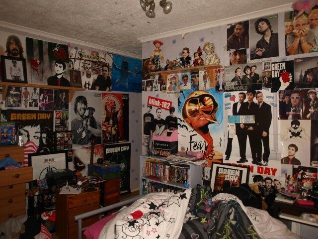 a bedroom with many pictures on the wall and posters all over the room, including an unmade bed