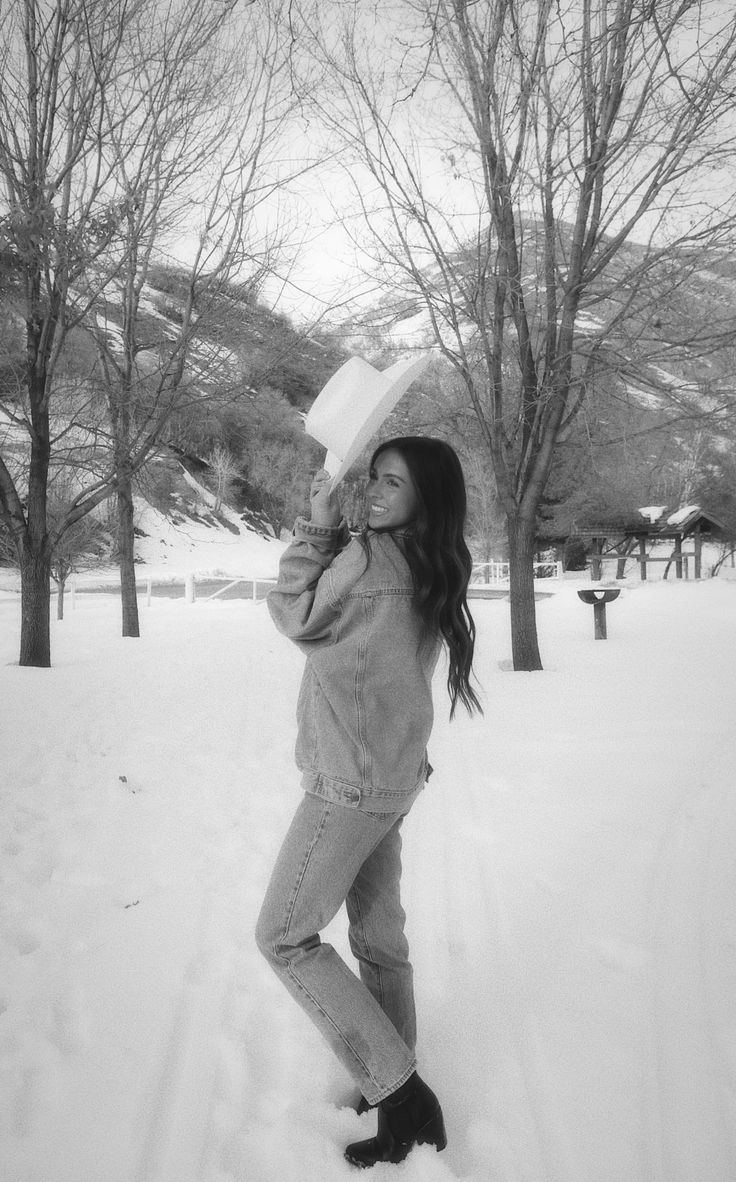 a woman standing in the snow with her hat on