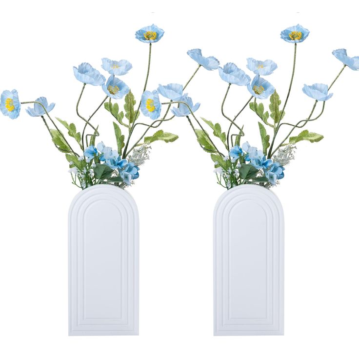 two white vases with blue and yellow flowers in them