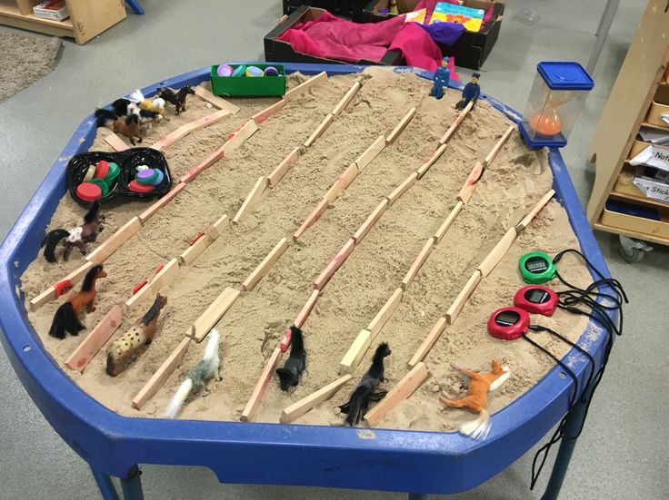 there is a sand table with toys in it