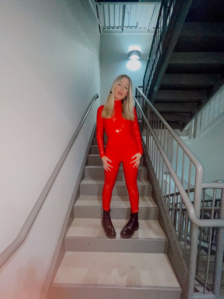 a woman in red is standing on some stairs