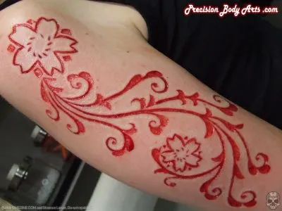 a woman's arm with red and white designs on the side, in front of a mirror