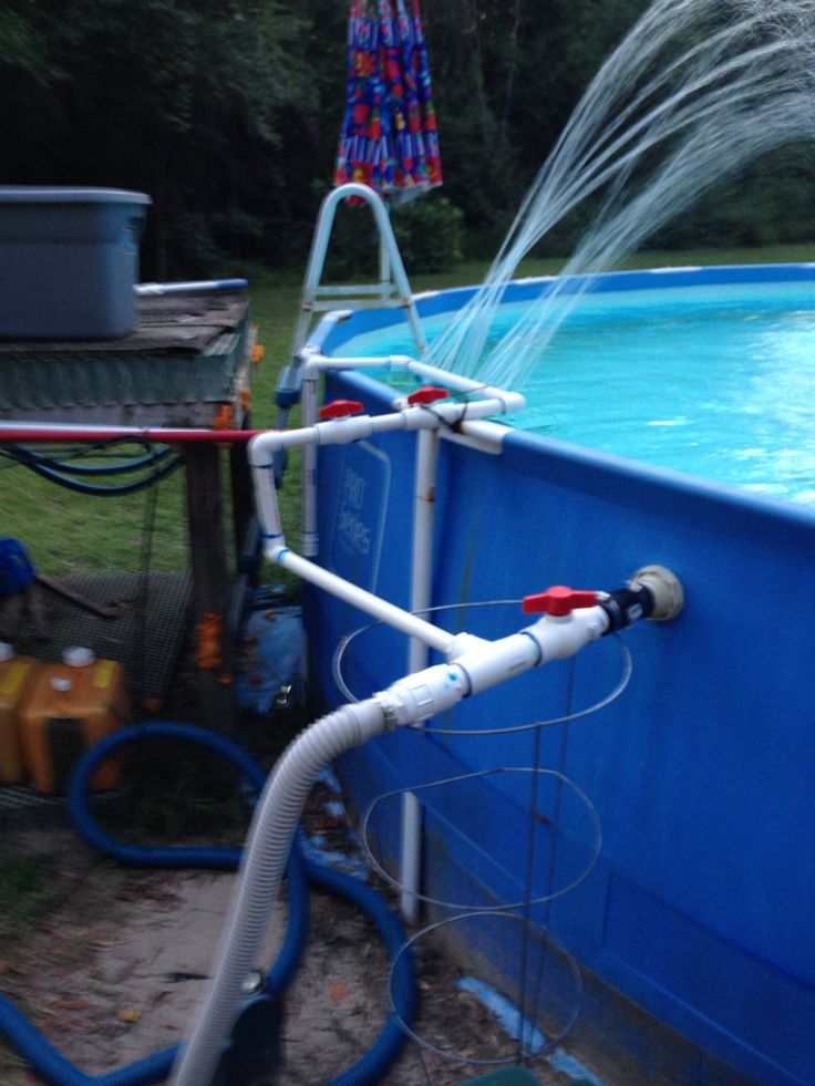 a blue swimming pool with water spewing from it and hoses attached to the side