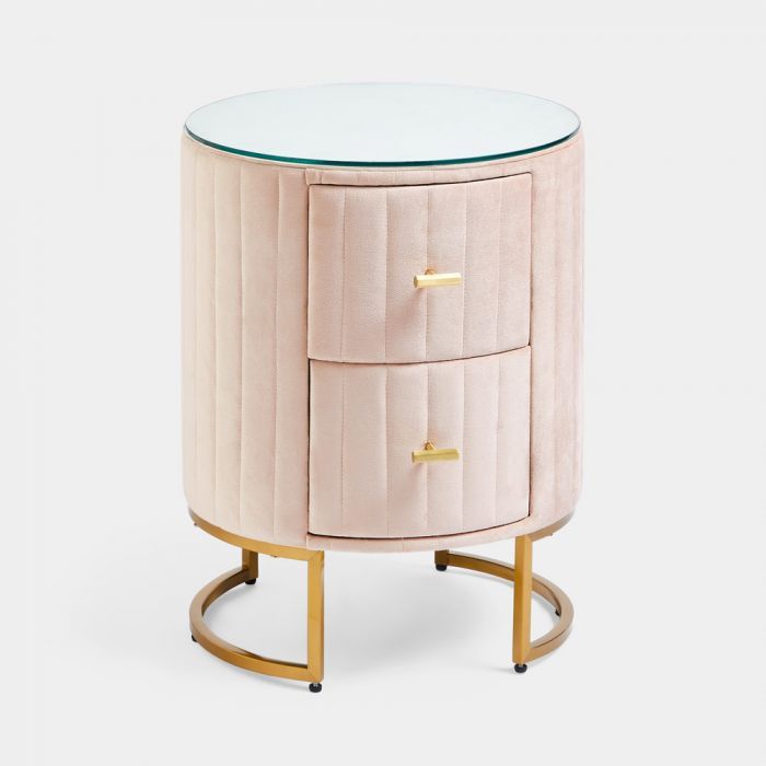 a pink and gold side table with two drawers on one end, and a glass top on the other