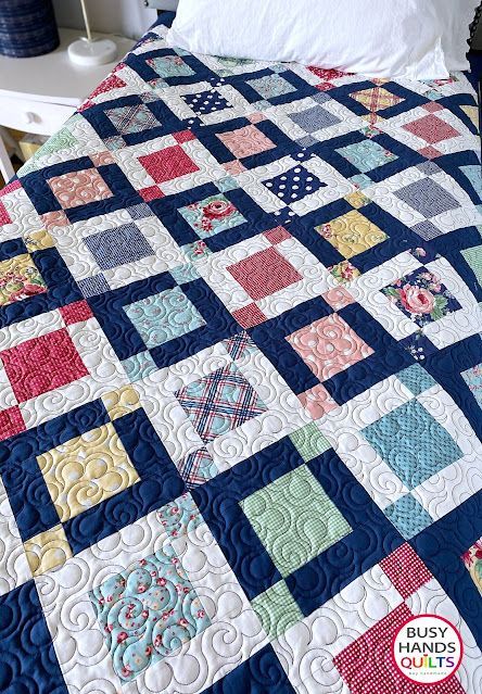 a bed with a blue and white quilt on it