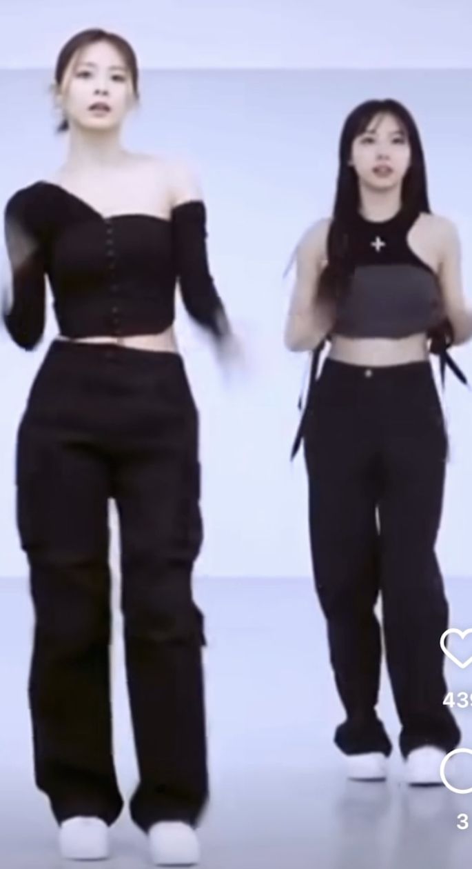 two women in black outfits standing next to each other with their hands on their hips