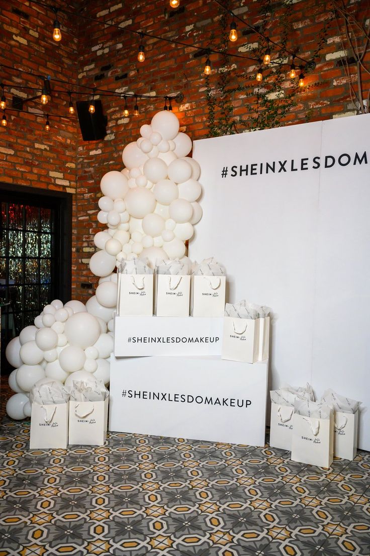 balloons are stacked on top of boxes in front of a brick wall