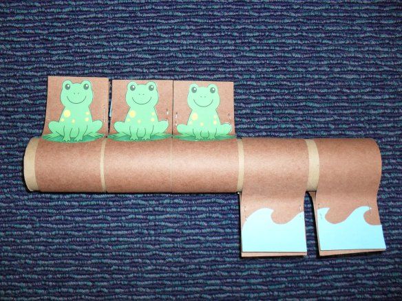 the roll of toilet paper has three green cats on it and is taped to one side