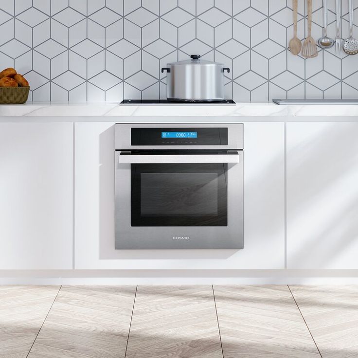 an oven in the middle of a kitchen with white walls and tile flooring on the wall