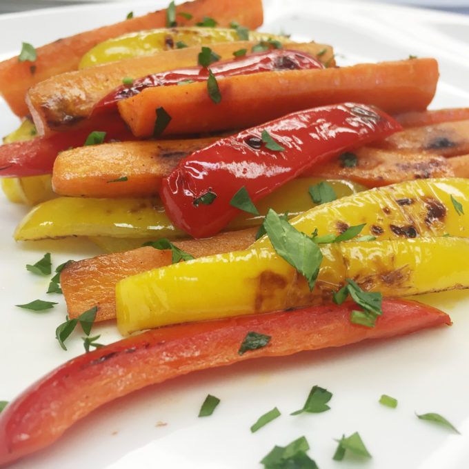 a white plate topped with carrots, peppers and parsley on top of it