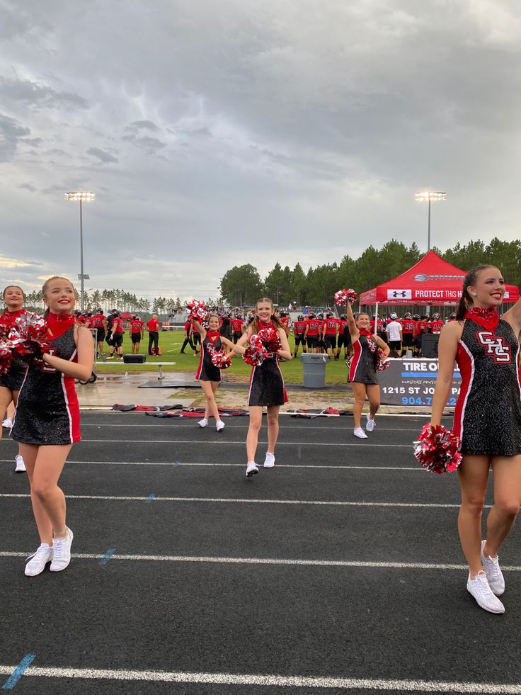 the cheerleaders are all dressed in red and black