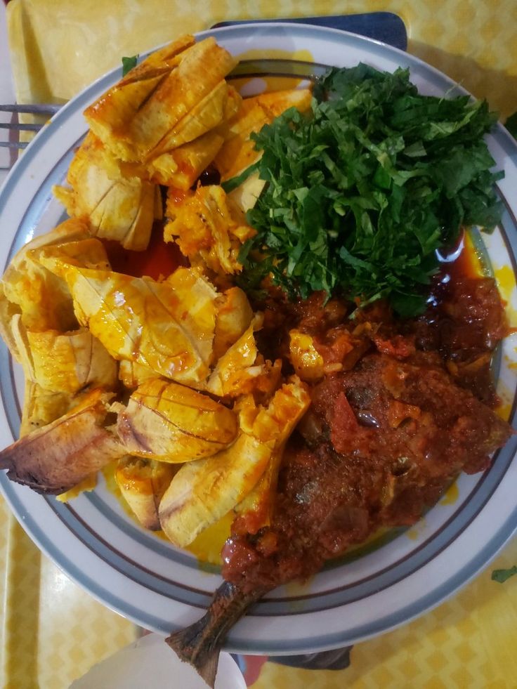 a white plate topped with lots of food on top of a yellow and white table cloth