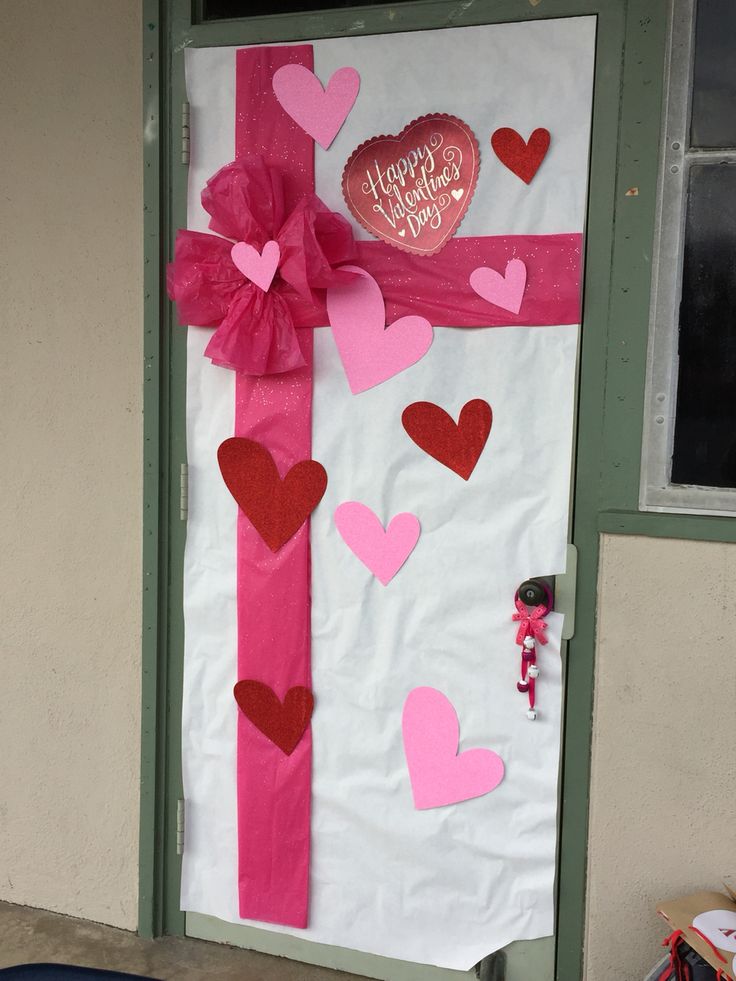 a door decorated with paper hearts and a pink ribbon