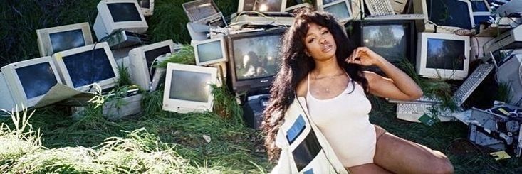 a woman sitting on the ground surrounded by old televisions