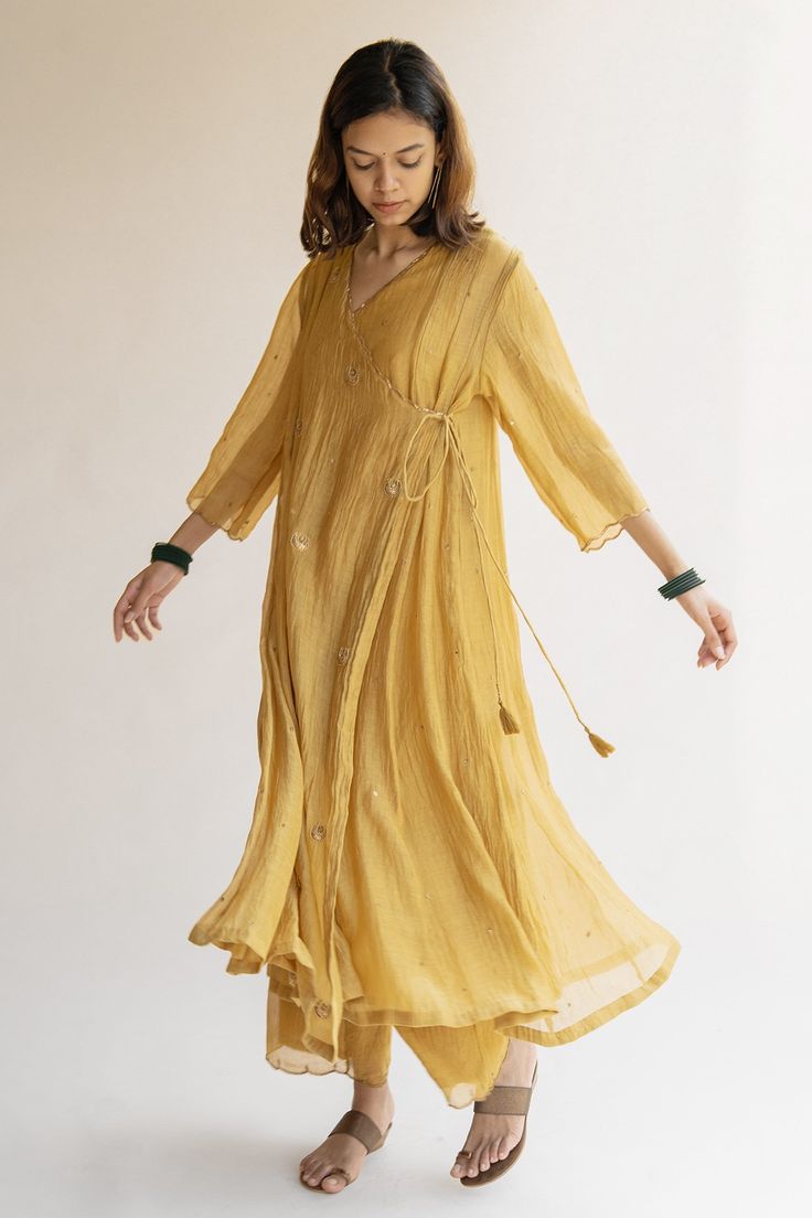 Honey mustard chanderi angrakha kurta with embroidered chaand bootas and nakshi kangri.
Component: 1
Pattern: Embroidered
Type Of Work: Nakshi kangri, chaand boota, dots
Neckline: V neck
Sleeve Type: Three quarter
Fabric: Chanderi
Color: Yellow
Other Details: 
Scallop neckline and cuffs
Note: Pant worn by the model is not for sale
Occasion: Work, Mehendi - Aza Fashions Angrakha Kurta For Women, Scallop Neckline, Kurta And Palazzo, Kurta For Women, Palazzo Set, Honey Mustard, Aza Fashion, Sleeve Type, Three Quarter