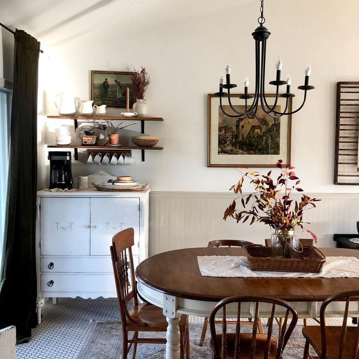 a dining room table with chairs and a chandelier hanging from the ceiling above it