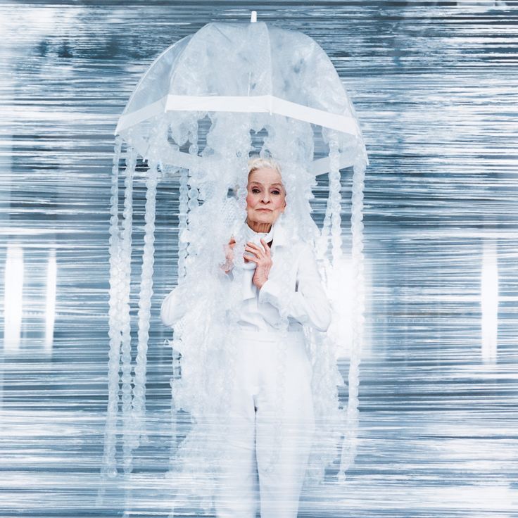 a woman in white is holding an umbrella with icicles hanging from the top and sides