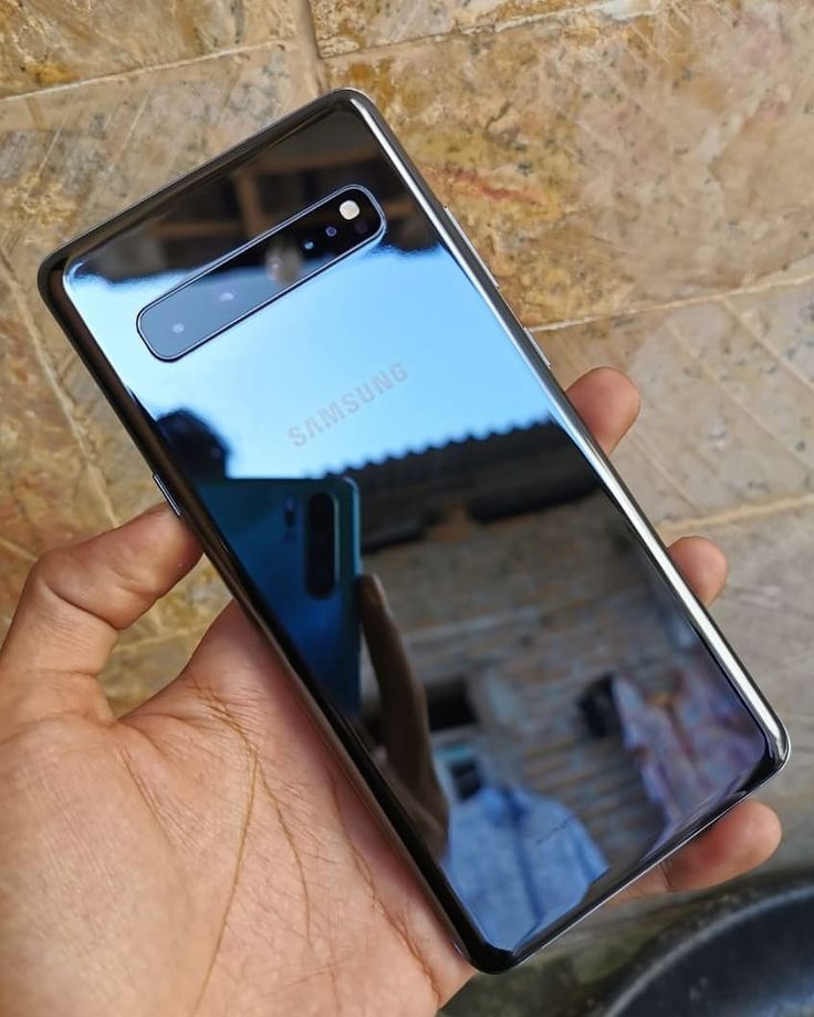 a hand holding a samsung note 9 in front of a mirror