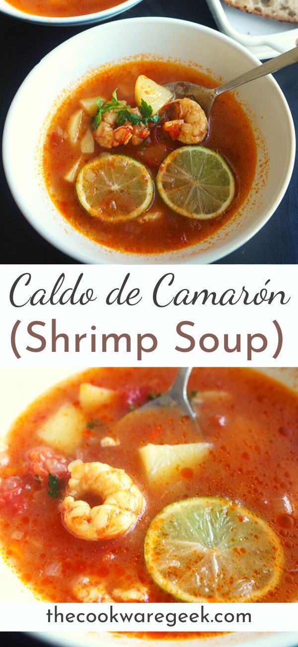 two bowls of soup with shrimp, lemons and bread on the side for garnish