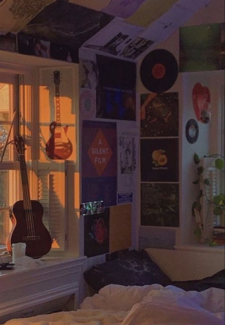 there are many different pictures on the wall in this room, including guitars and other things