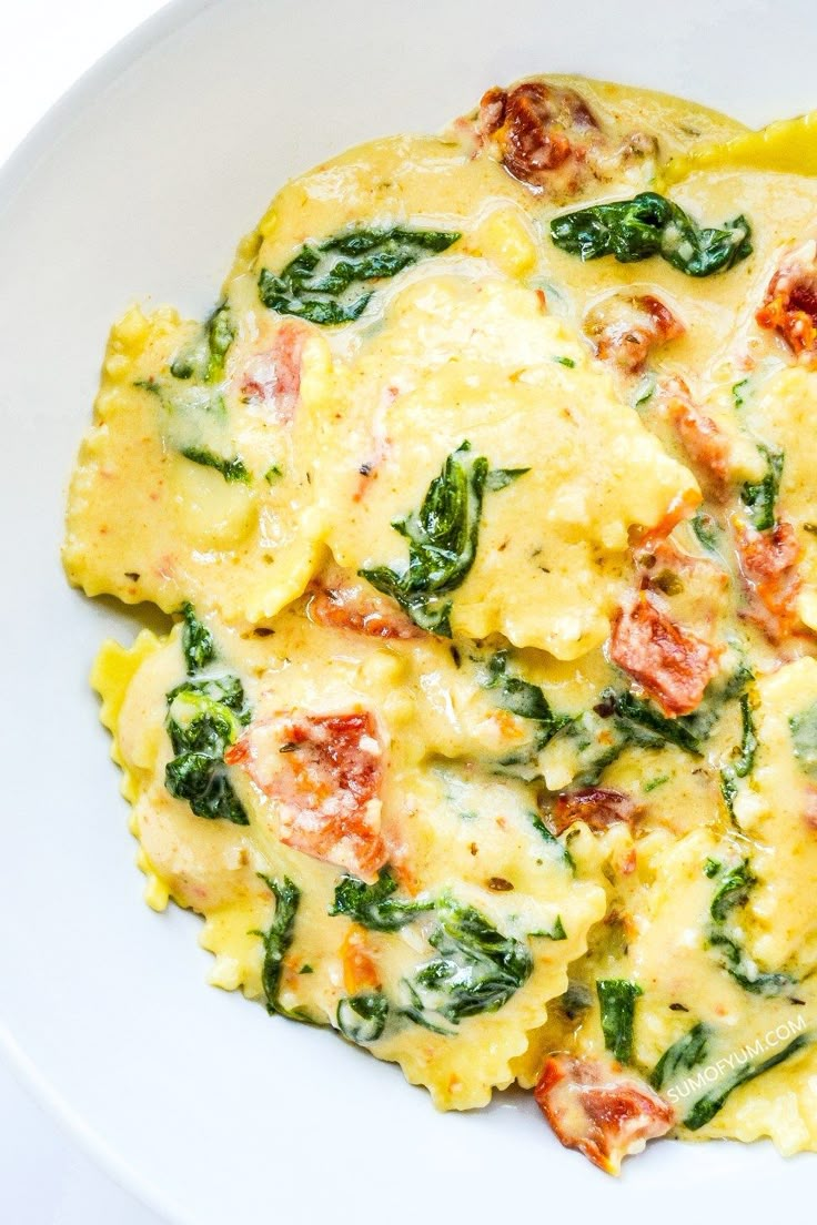 an omelet with spinach and tomatoes in a white bowl on a table