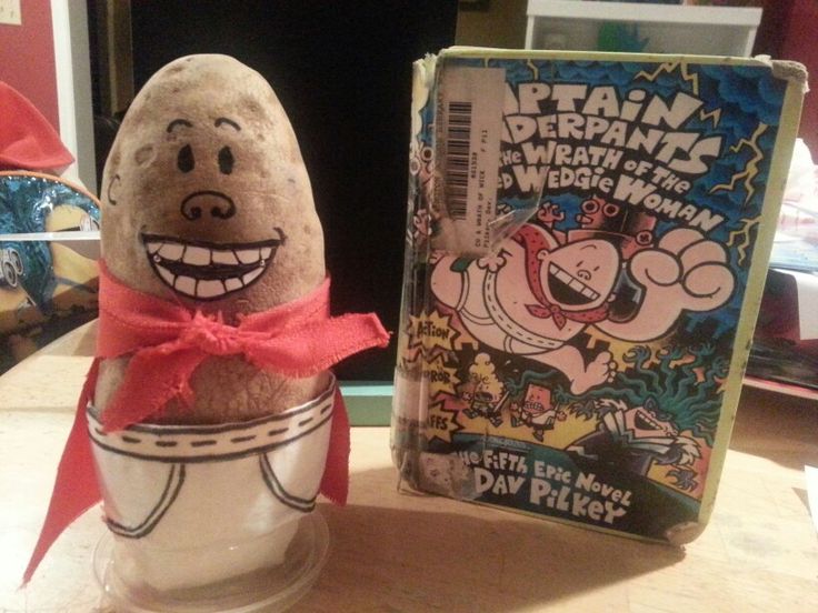 an egg with a red bow is sitting on a table next to a comic book