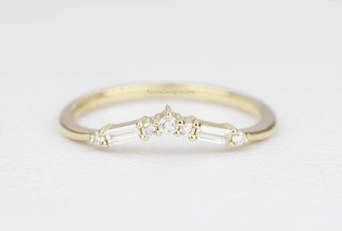 a gold ring with three stones on the side and two small diamonds in the middle