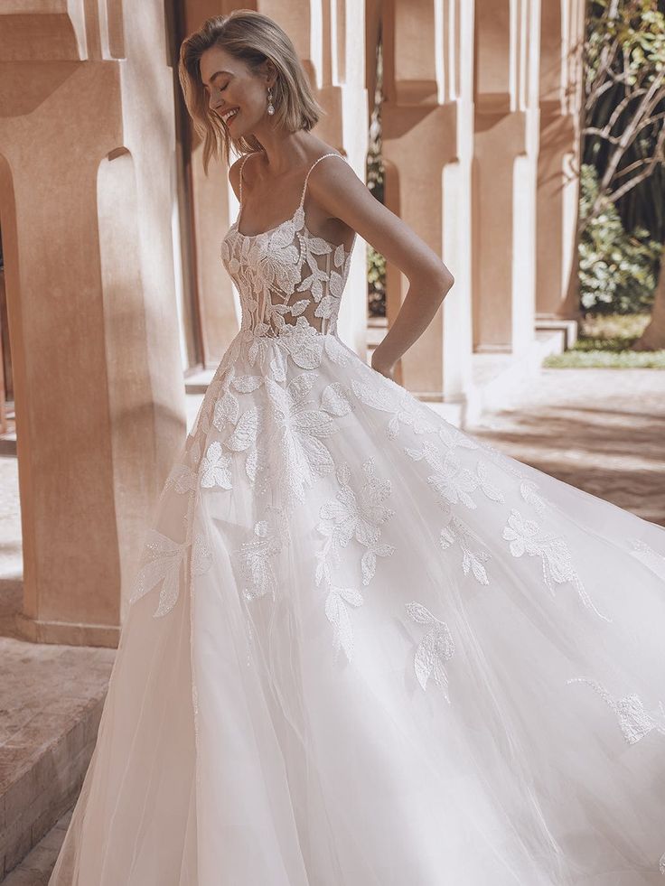 a woman in a wedding dress standing outside