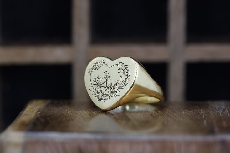 This Birds Signet Ring, crafted in a heart shape, is a poetic expression of love and nature. Featuring an artistic depiction of birds, it symbolizes freedom, harmony, and romance. Ideal for bird lovers or those who appreciate the beauty of nature's creatures, this ring blends the elegance of avian art with the romantic symbolism of a heart. It's a unique and meaningful piece that adds a touch of natural charm to any ensemble. 📏 Ring Size: Choose your preferred size from the drop-down menu. 💍 S Symbolic Heart-shaped Wedding Ring, Symbolic Heart Shaped Wedding Rings, Symbolic Heart Shaped Rings As Gifts, Symbolic Heart Ring For Valentine's Day Gift, Heirloom Oval Heart Ring Gift, Valentine's Day 14k Engraved Ring Gift, Nature-inspired Engraved Ring As A Gift, Nature-inspired Engraved Ring For Gifts, Nature-inspired Engraved Round Ring For Gift