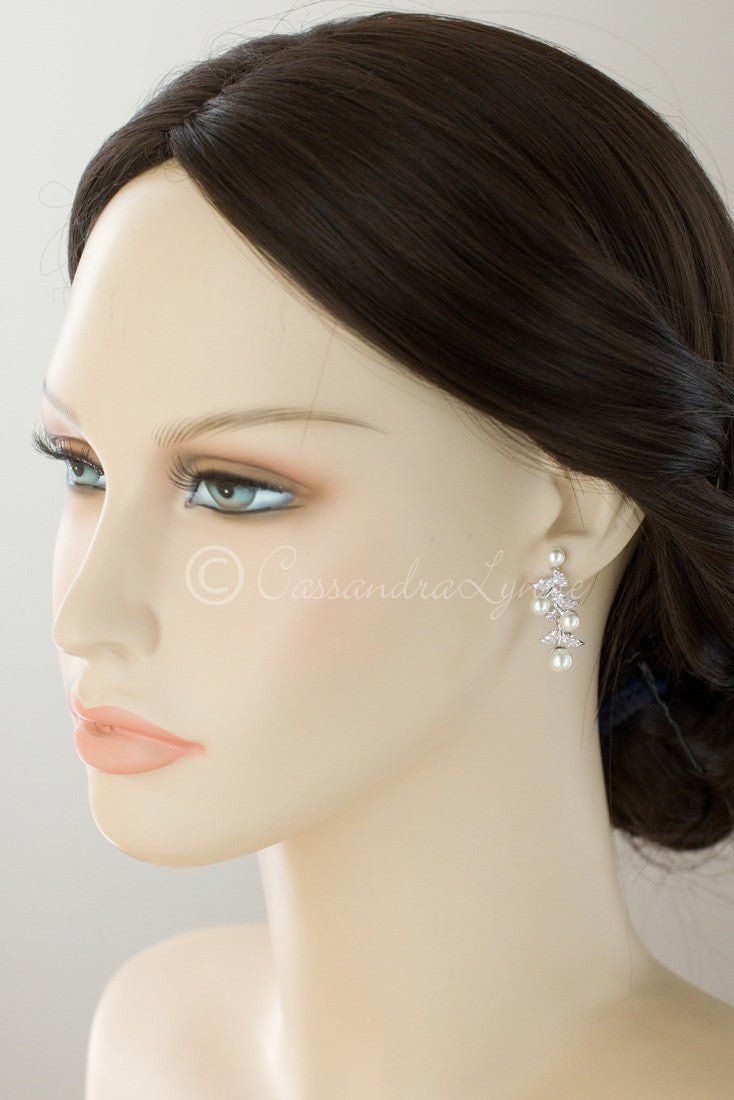 a female mannequin head wearing a white dress with earrings on it's ear