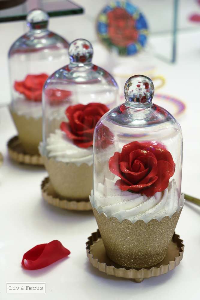 three glass domes with red roses in them