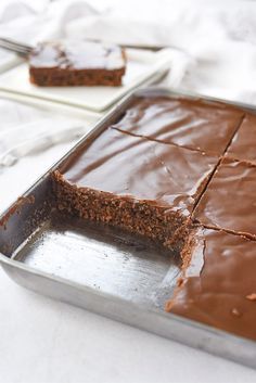 there is a chocolate cake that has been cut into squares and placed on a pan