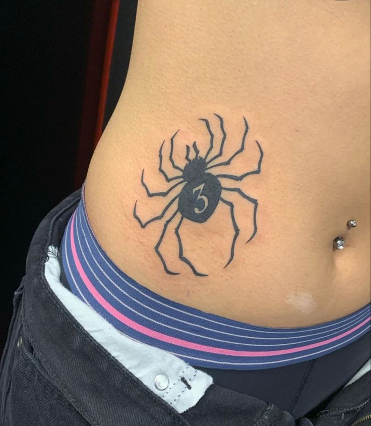 a woman with a spider tattoo on her stomach