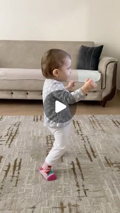 a toddler is playing with a pillow in the living room