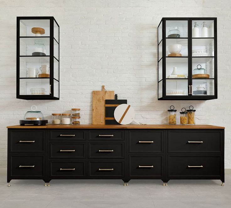 a kitchen with two black cabinets and shelves on each side, one is open to the other