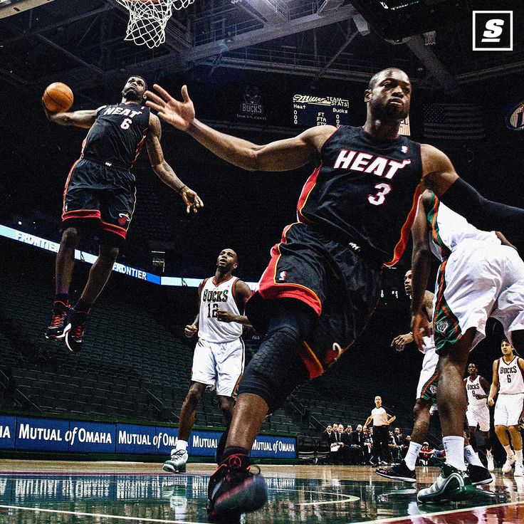 the basketball player is going to dunk the ball in front of the other players