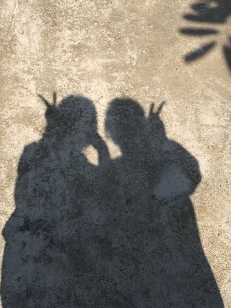 the shadow of two people standing next to each other