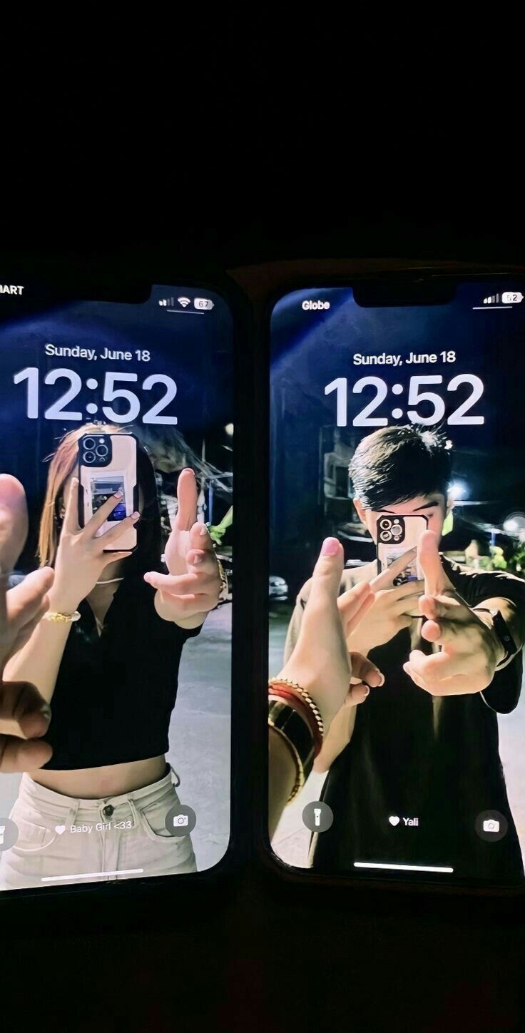 two people taking pictures with their cell phones in front of the same image as one person