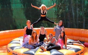 a group of young women sitting on top of an inflatable trampoline