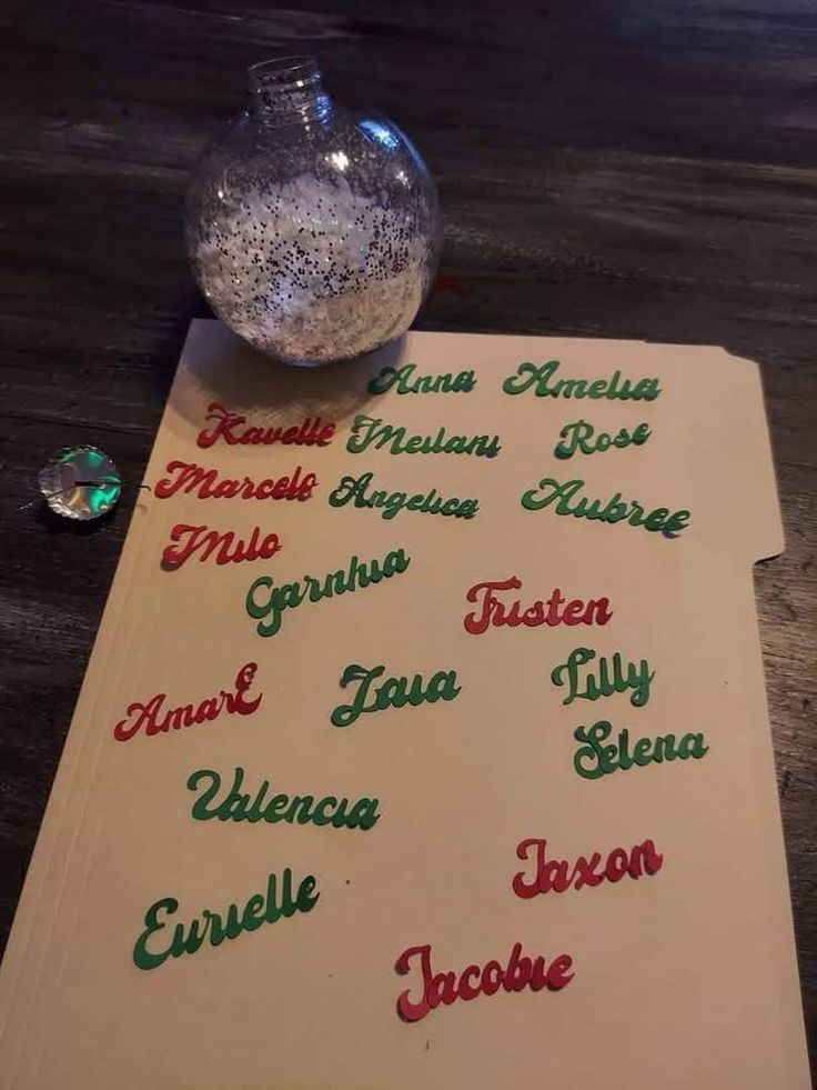 a table with some writing on it and a glass vase filled with water next to it