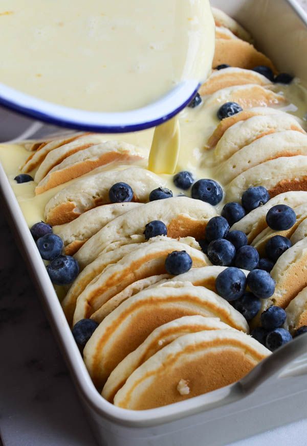 blueberries and cream cheesecakes on a plate with butter being drizzled over them