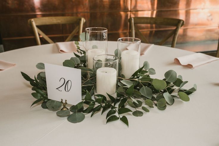 the table is set with candles and greenery