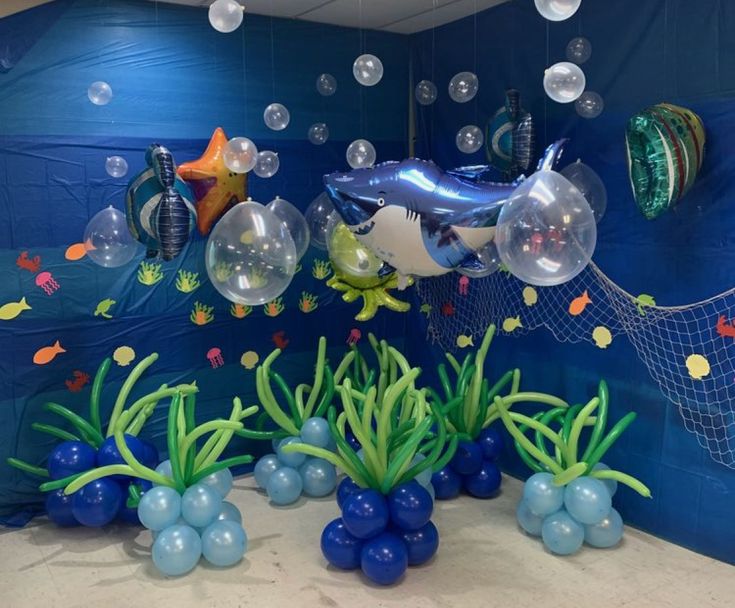 an under the sea theme with balloons, fish and other marine life in blue water