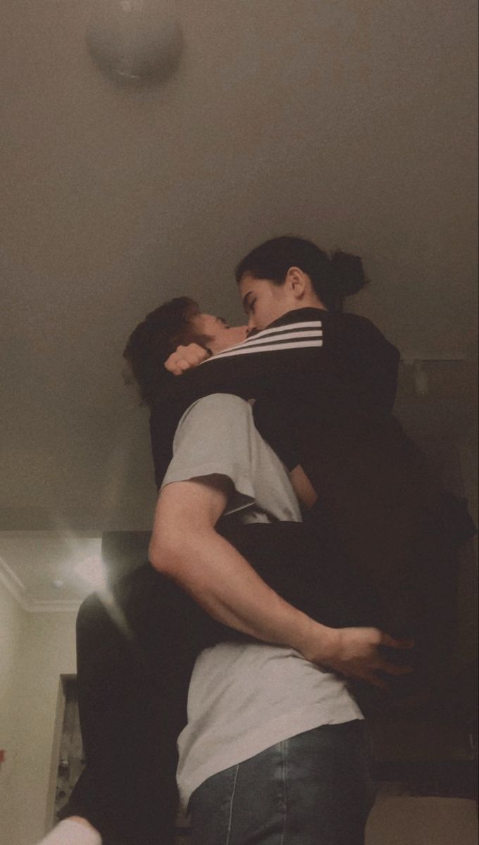 two people hugging each other in the middle of a room with a ceiling light above them