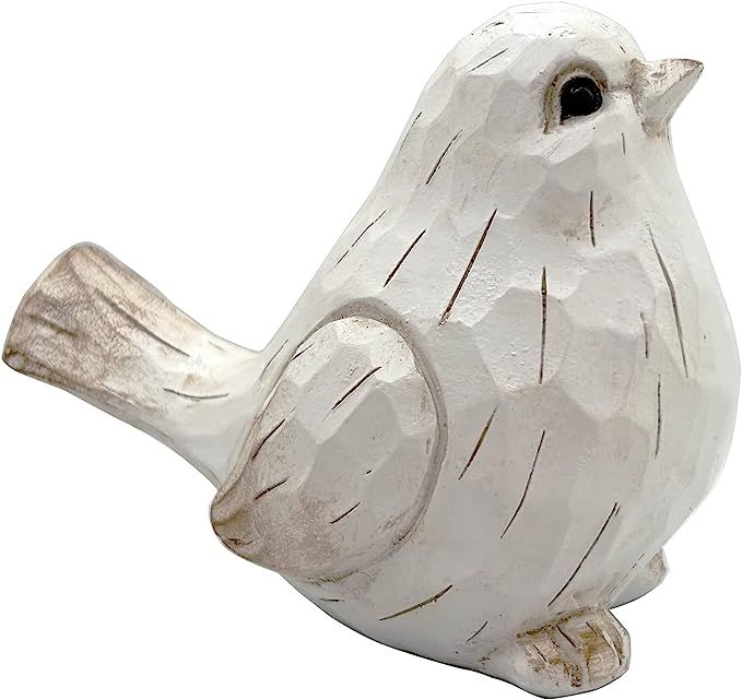 a white ceramic bird sitting on top of a wooden branch