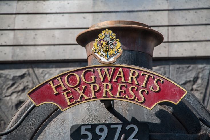 the hogwart's express sign is on top of an old fashioned train car